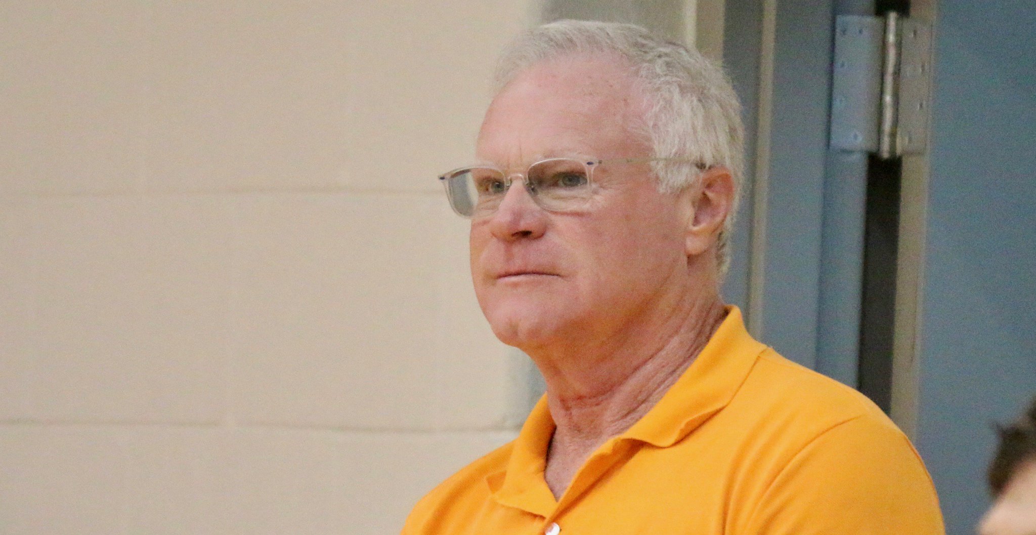 David Keith wearing an orange polo shirt and eye glasses