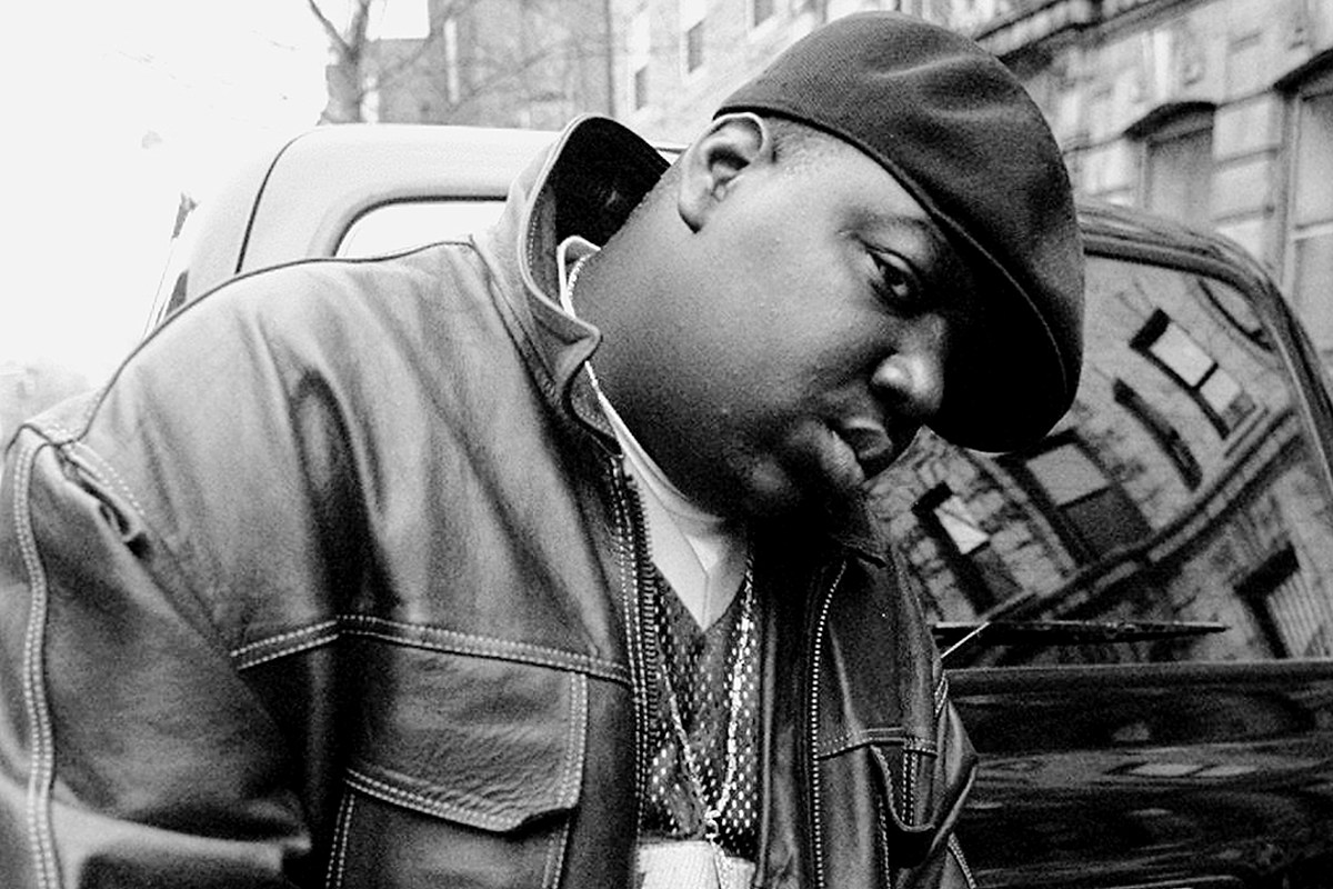 The Notorious B.I.G. wearing a leather jacket and a hat