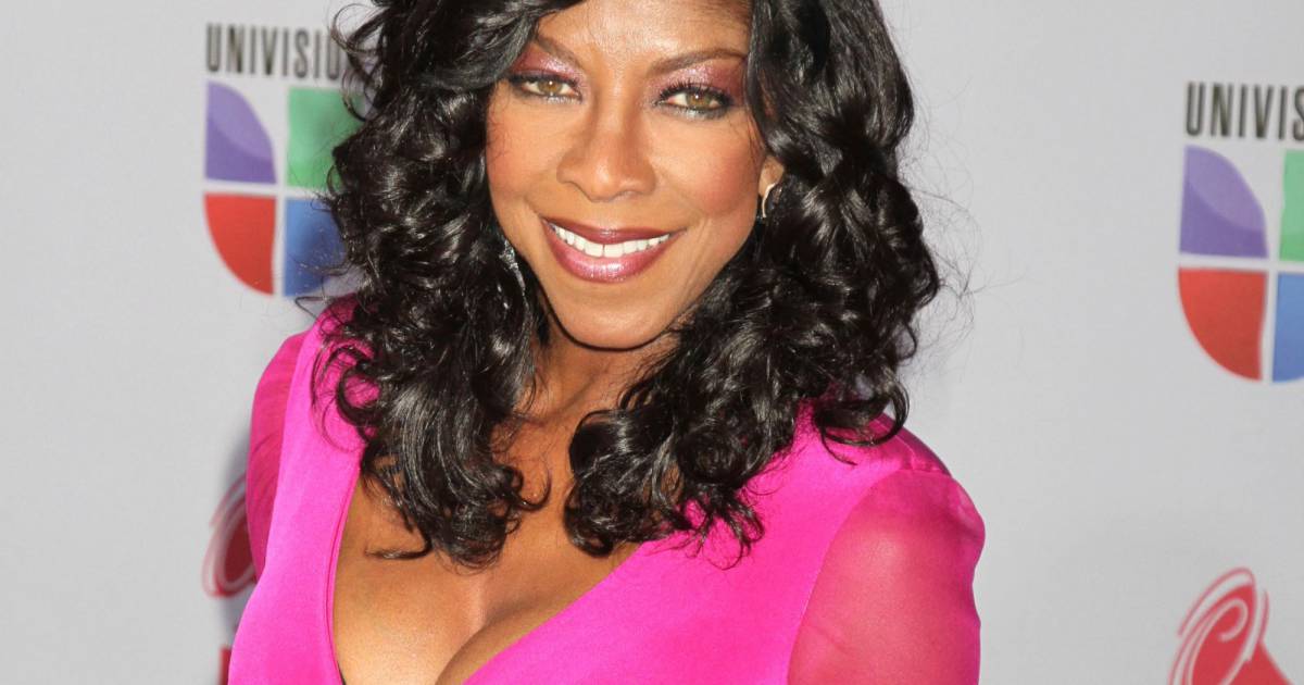 Smiling Natalie Cole in a pink dress