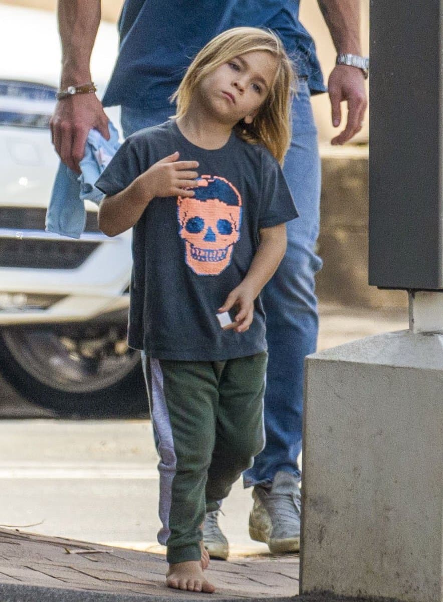 Tristan Hemsworth wearing a shirt with skull and jogging pants while walking barefoot