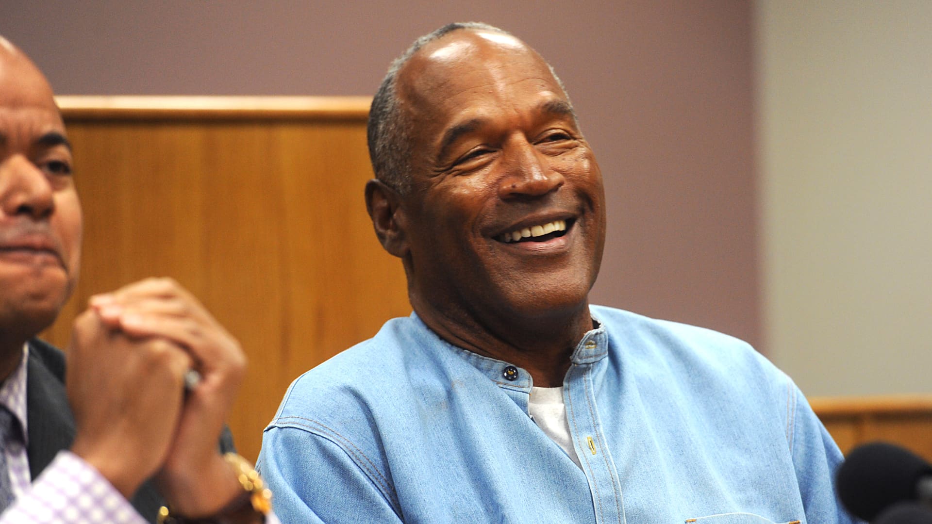 OJ Simpson laughing while wearing a blue polo