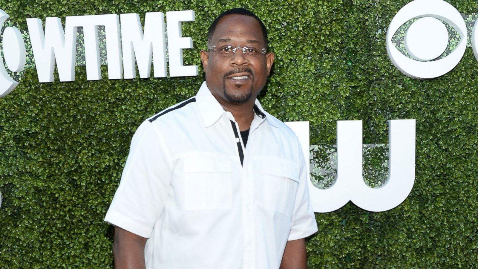 Martin Lawrence wearing a white polo and eyeglasses