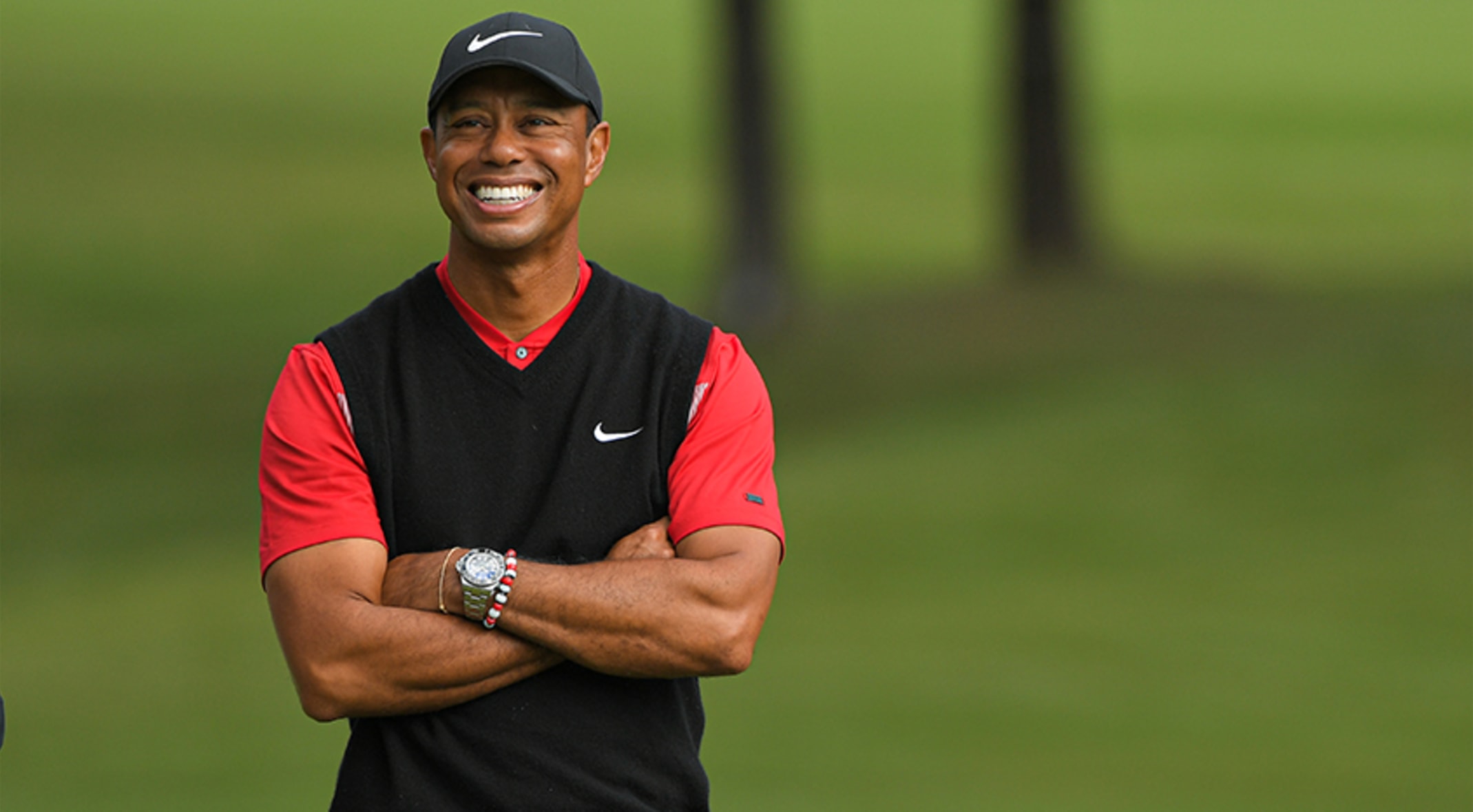 Tiger Woods wearing a red and black shirt and black cap