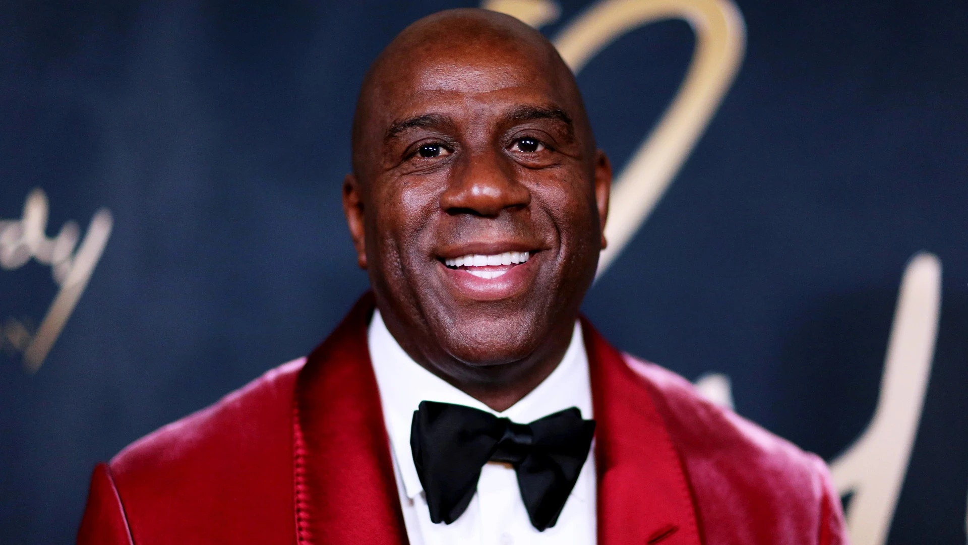 Magic Johnson wearing a red suit