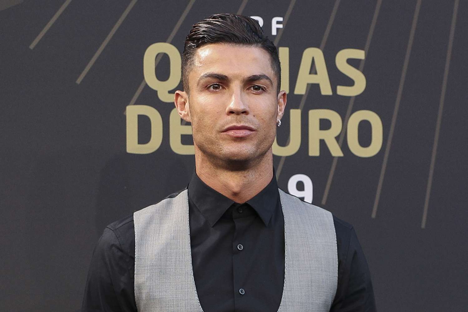 Cristiano Ronaldo wearing a black long sleeves polo and gray vest