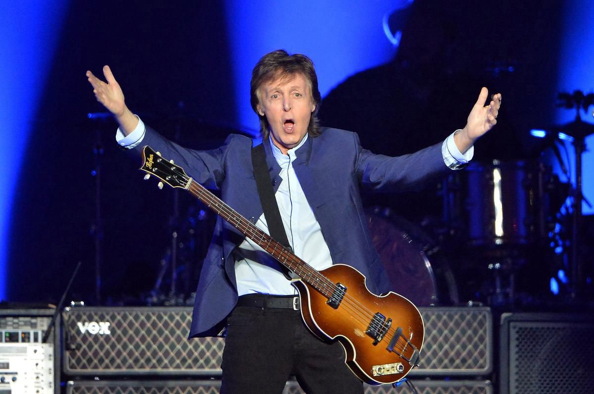 Paul McCartney wearring a blue suit and guitar