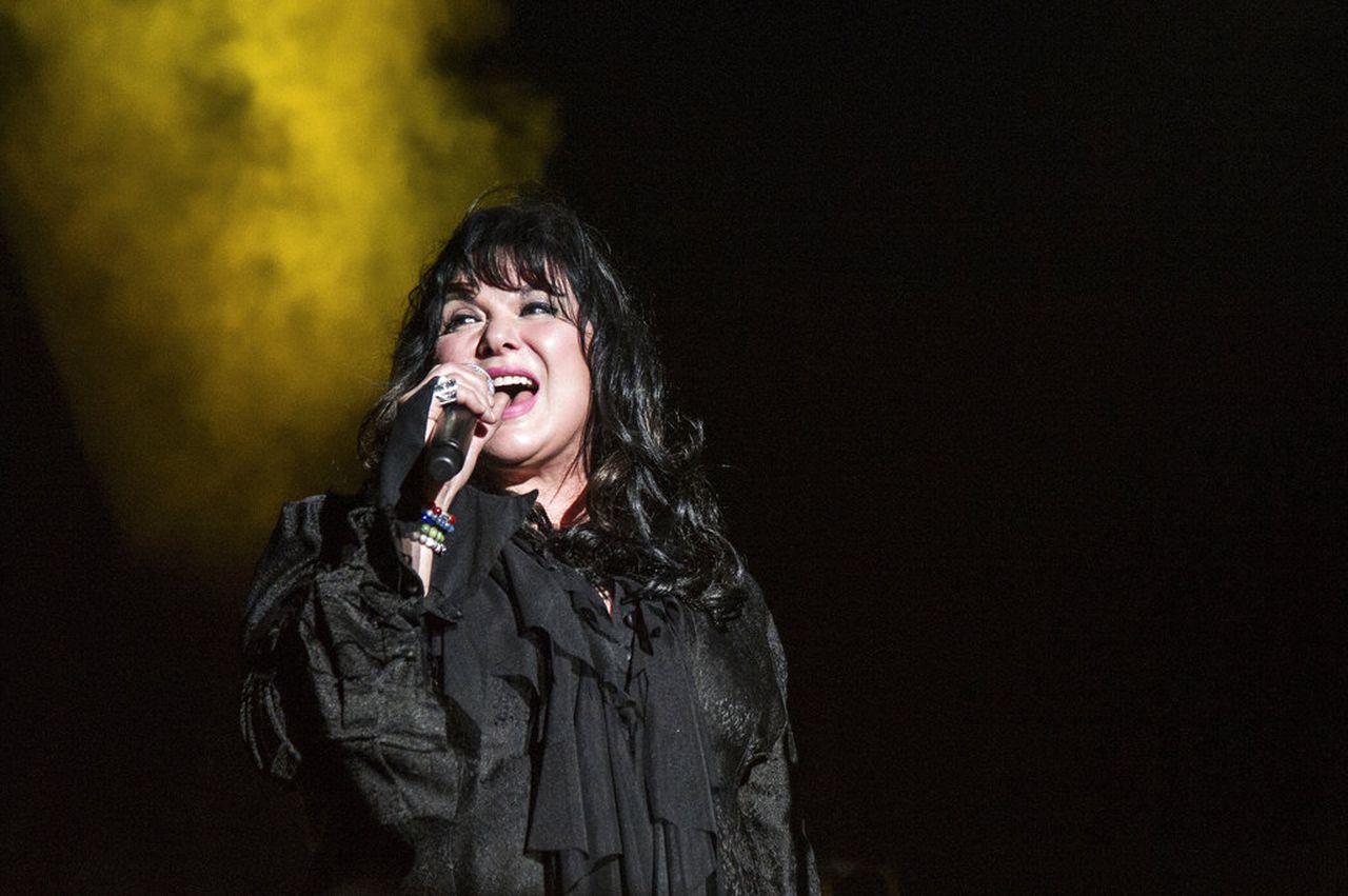 Ann Wilson wearing a black outfiit while singing