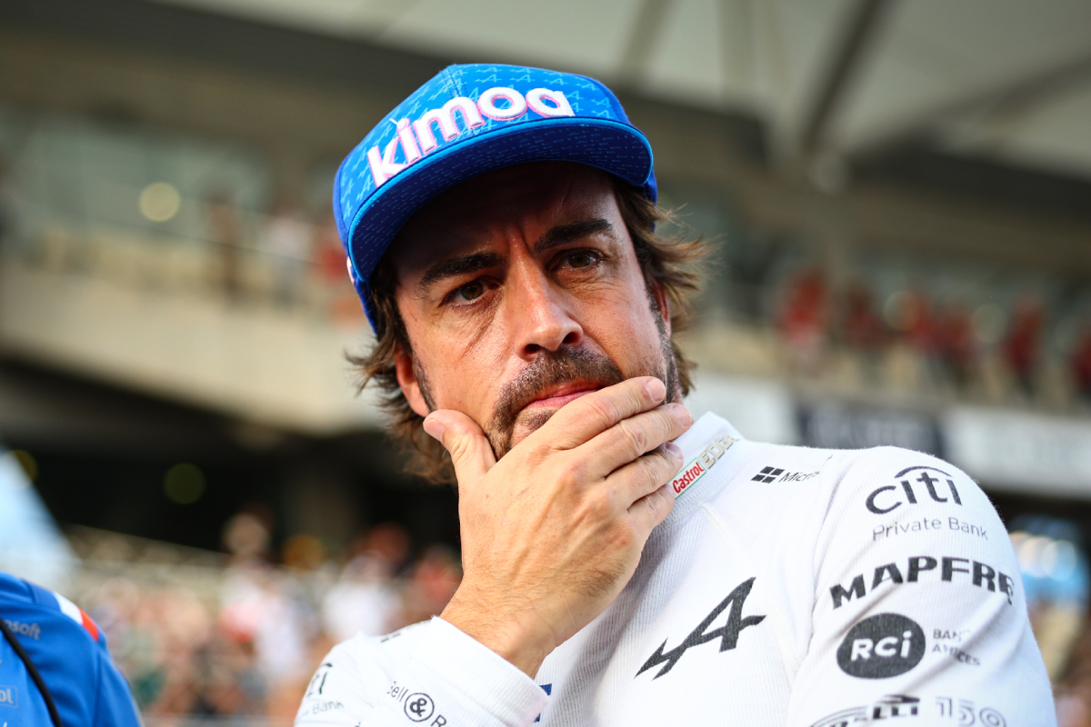 Fernando Alonso wearing white jacket and blue cap