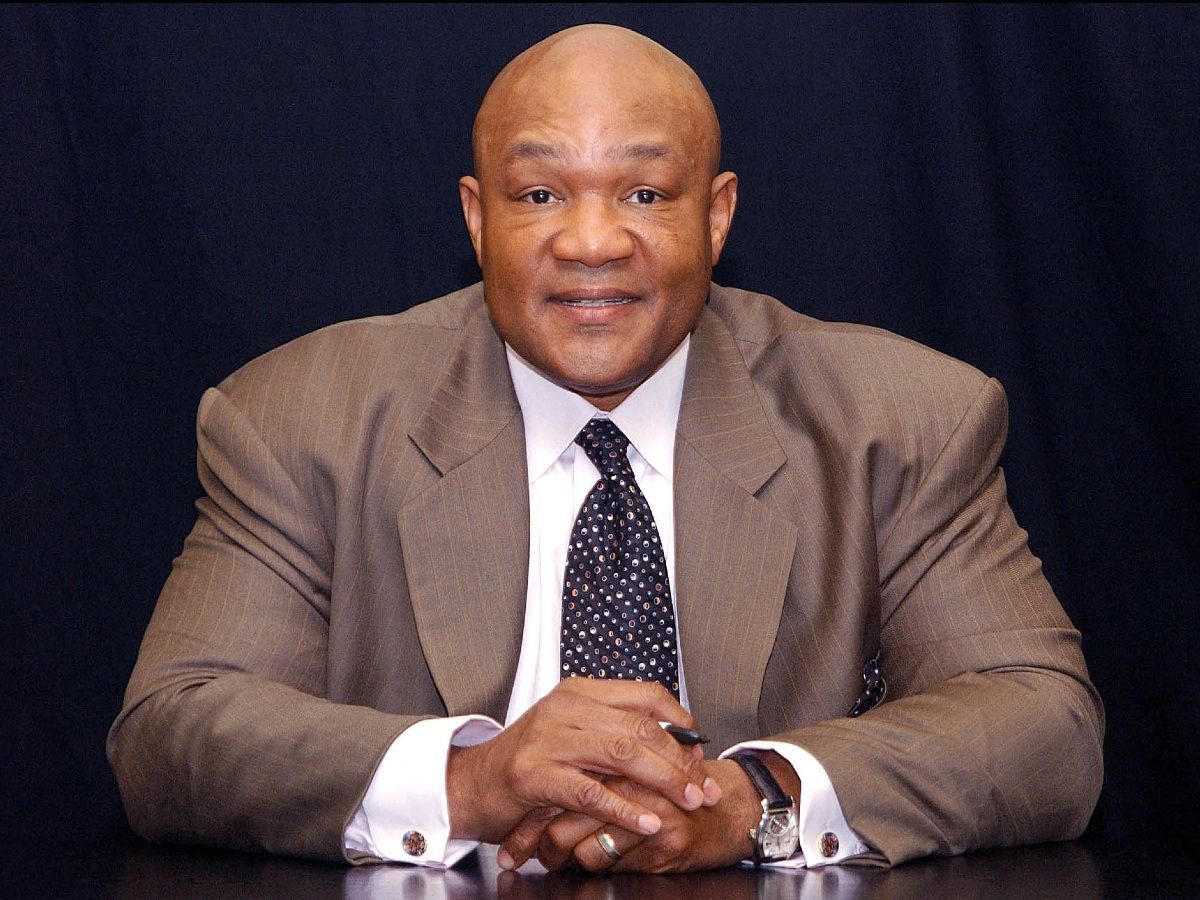 George Foreman wearing a brown suit and polka dots tie