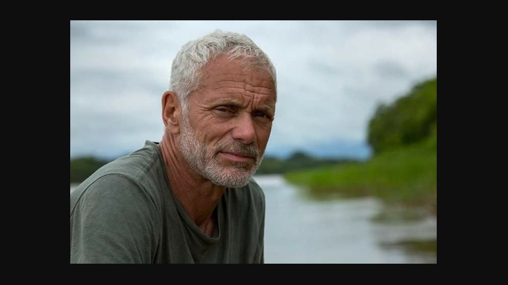 Jeremy Wade wearing a t-shirt while leaning forward for a photograph