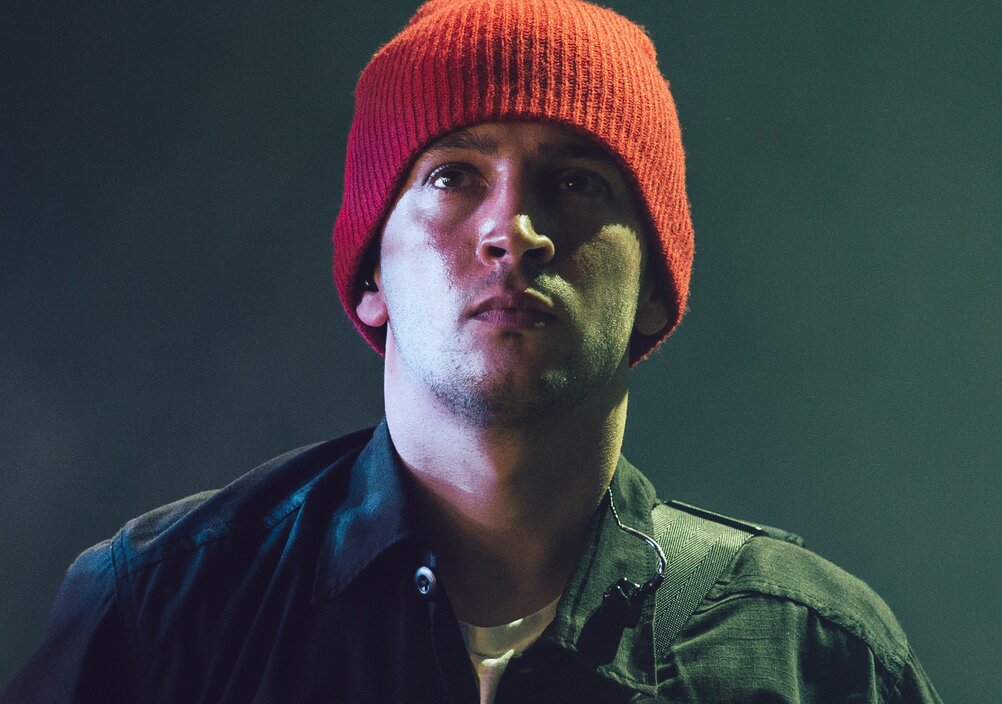 Tyler Joseph wearing a black jacket and a red beanie
