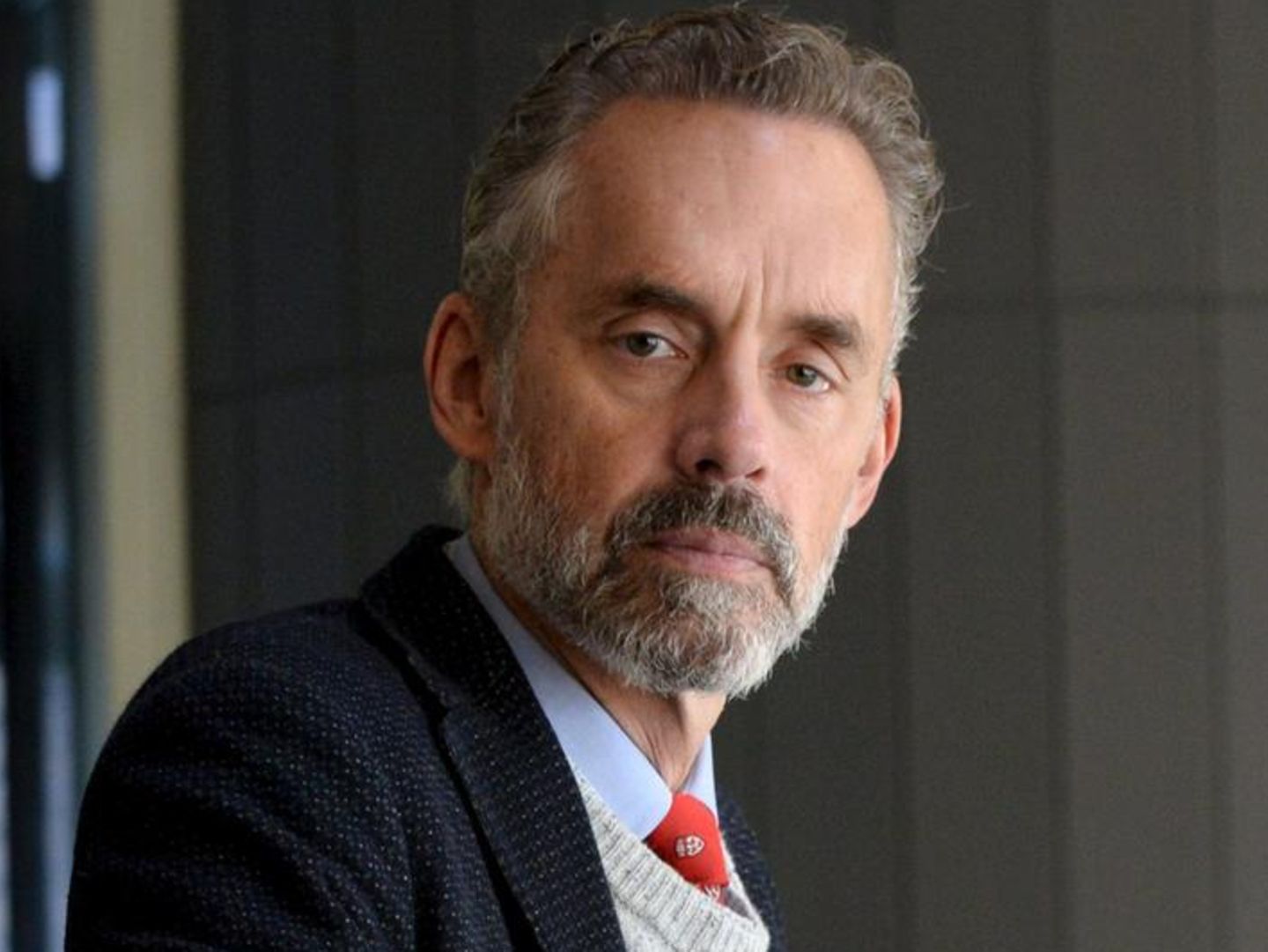 Jordan Peterson wearing a blue suit with a straight face