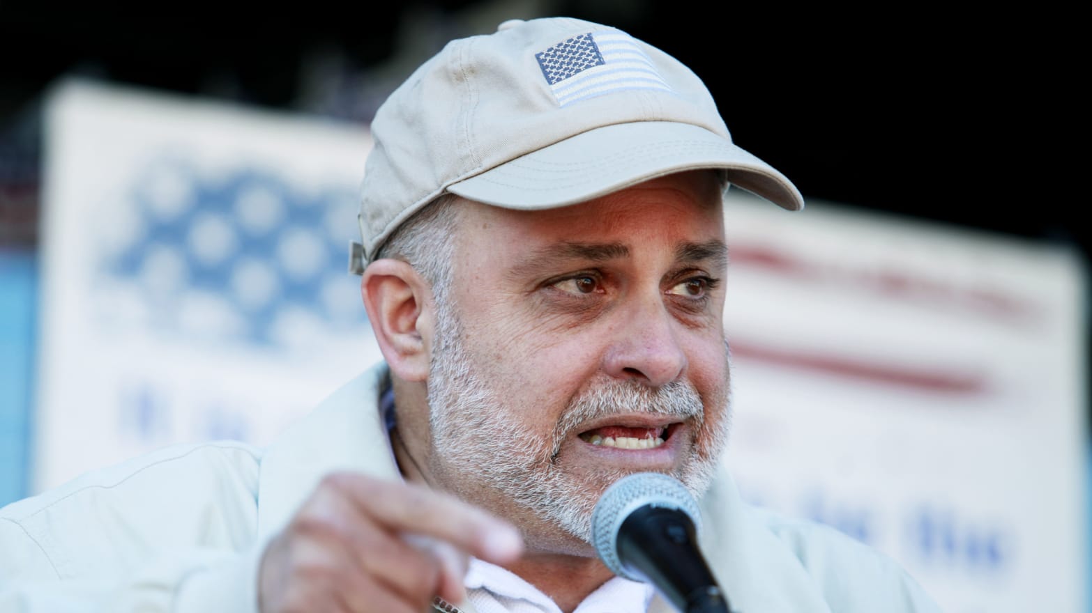 Mark Levin wearing a face cap with the flag of the United States as he speaks into a microphone