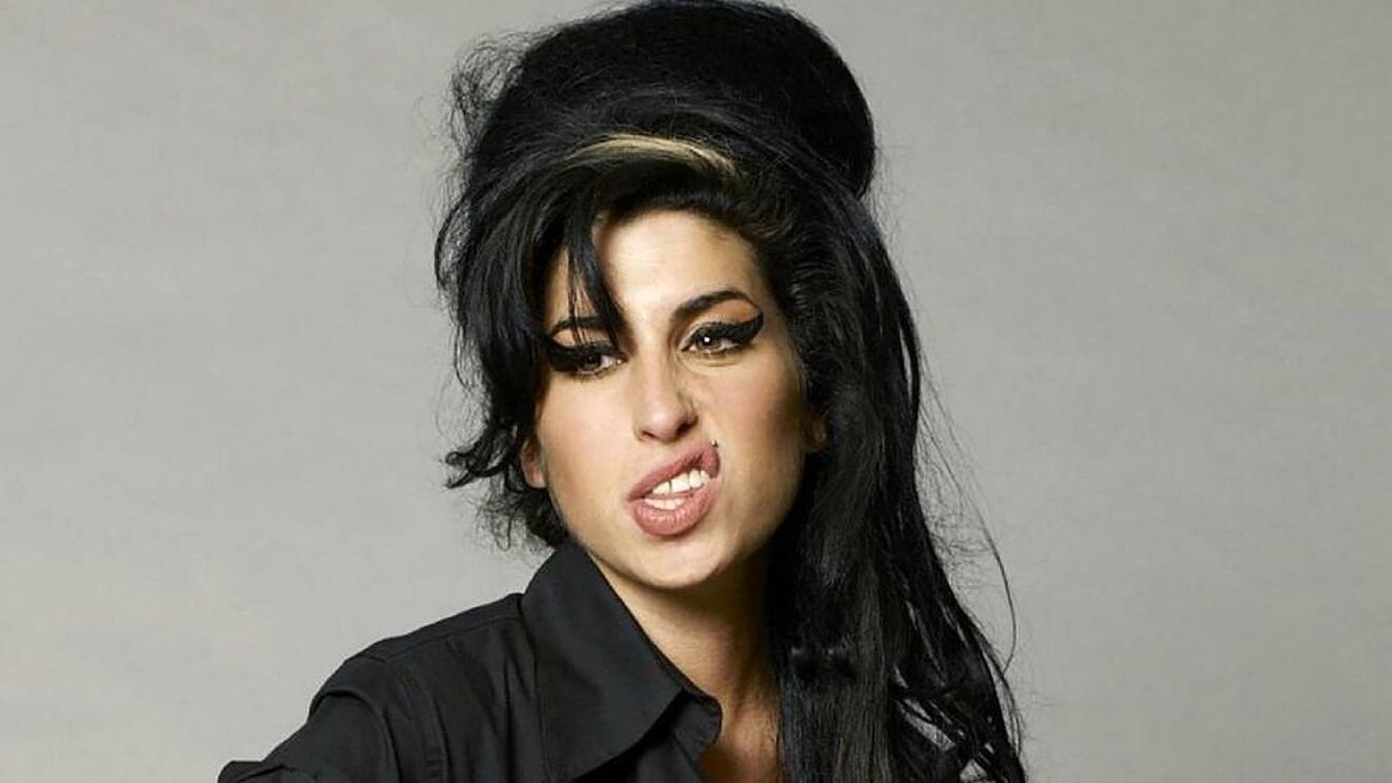 Amy Winehouse wearing a black polo long sleeves 