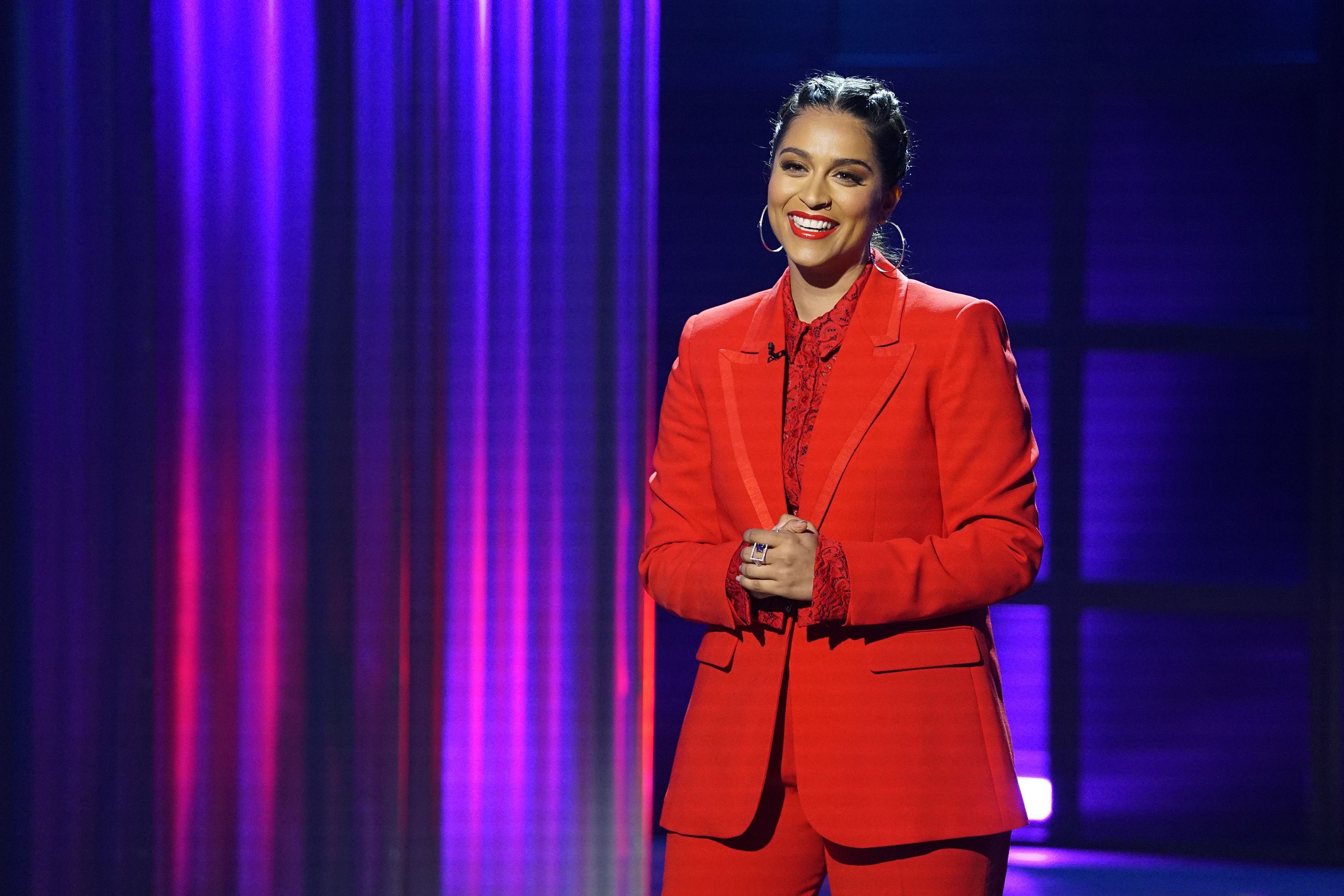 Lilly Singh wearing a red suit