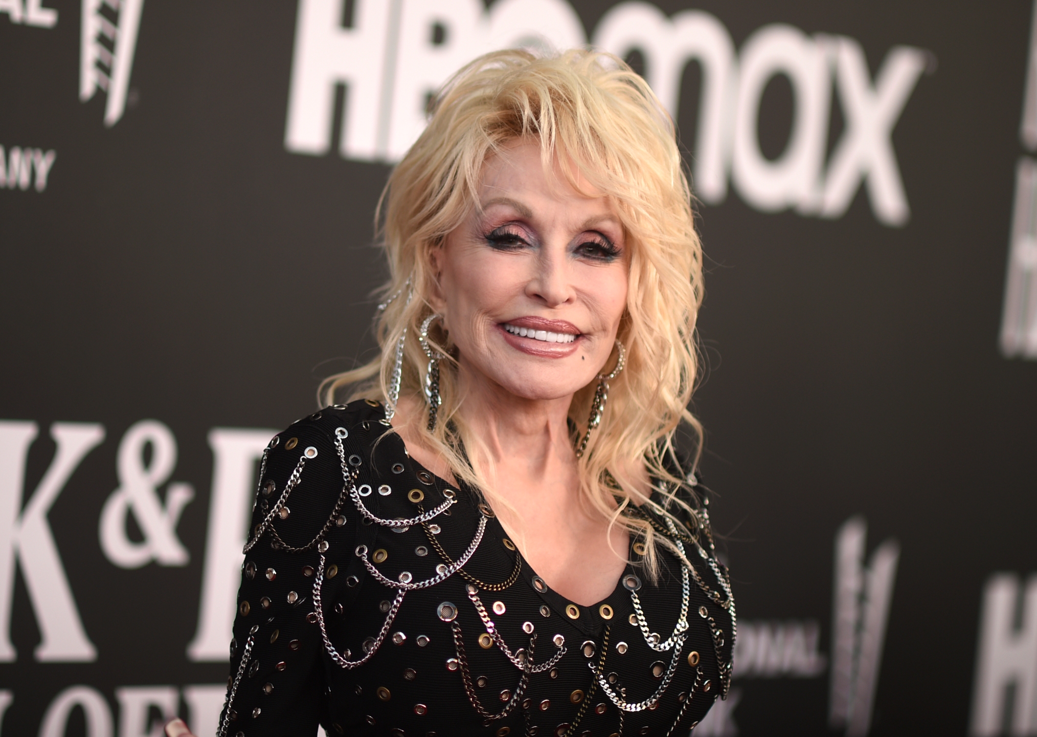 Dolly Parton wearing a black dress with chains