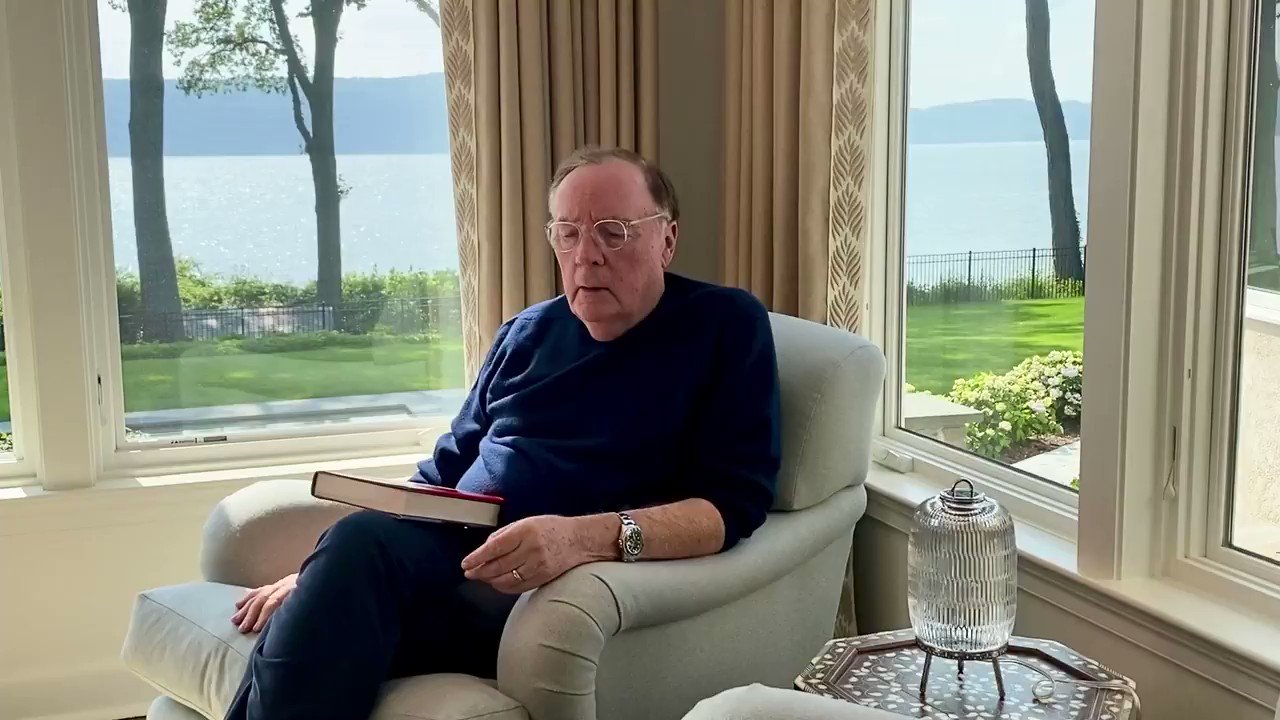 James Patterson sitting on a sofa with a book on his lap