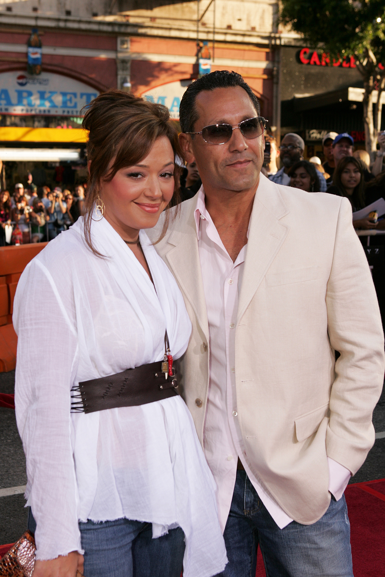 Angelo Pagan wearing  mocha colored coat and Leah Remini wearing a white long sleeves polo