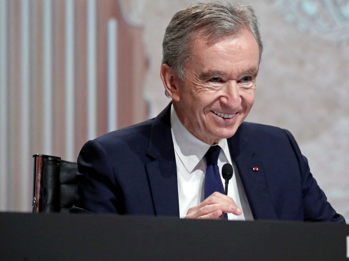 Bernard Arnault wearing a blue suit while holding a mic