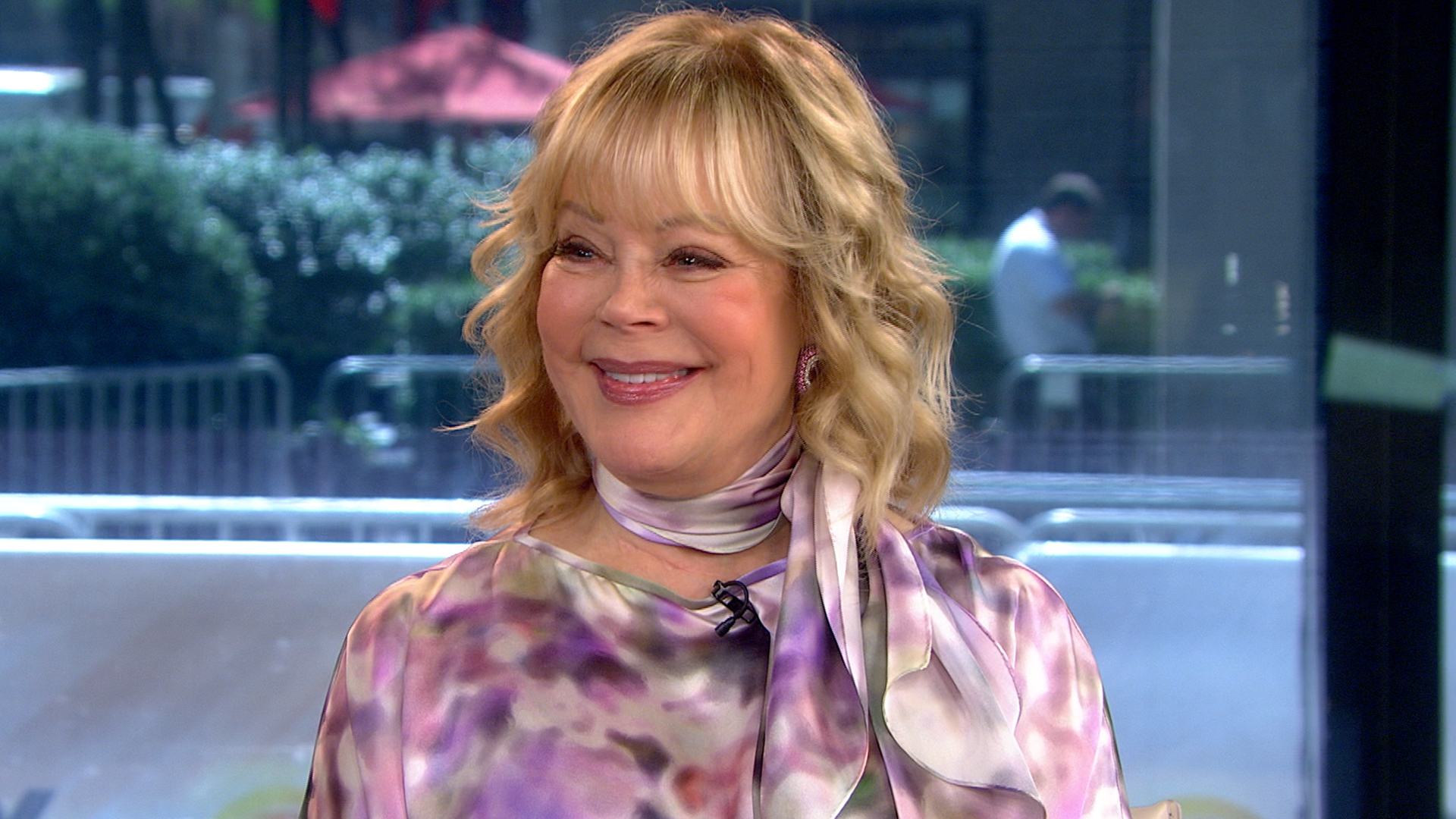 Candy Spelling wearing a matching purple scarf and top