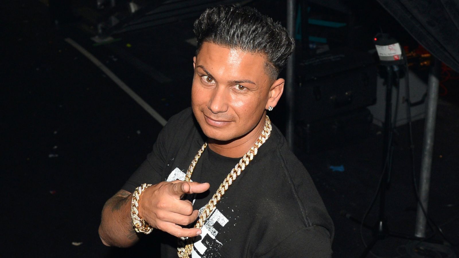 DJ Pauly D wearing a black shirt and gold chain