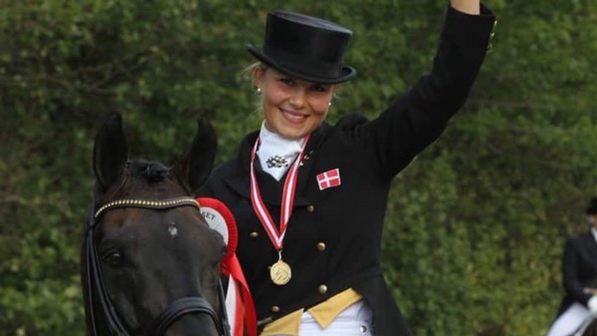 Anna Kasprzak wearing a black equestrian uniform with a medal while riding a horse