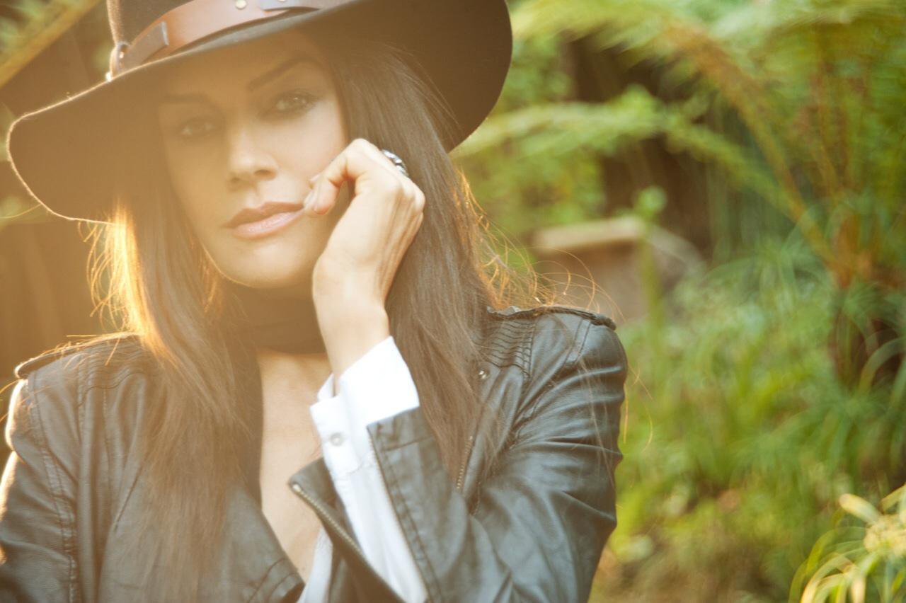 Deborah Falconer wearing a black leather jacket and black cowboy hat