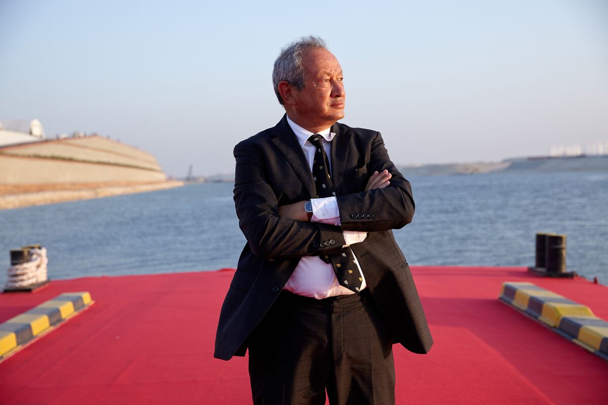 Naguib Sawiris wearing a black suit while crossing his arms