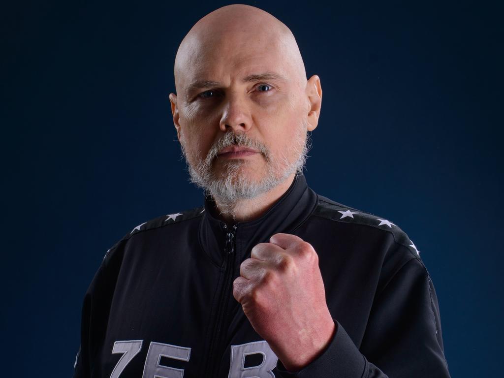Billy Corgan wearing a black jacket while showing his fist
