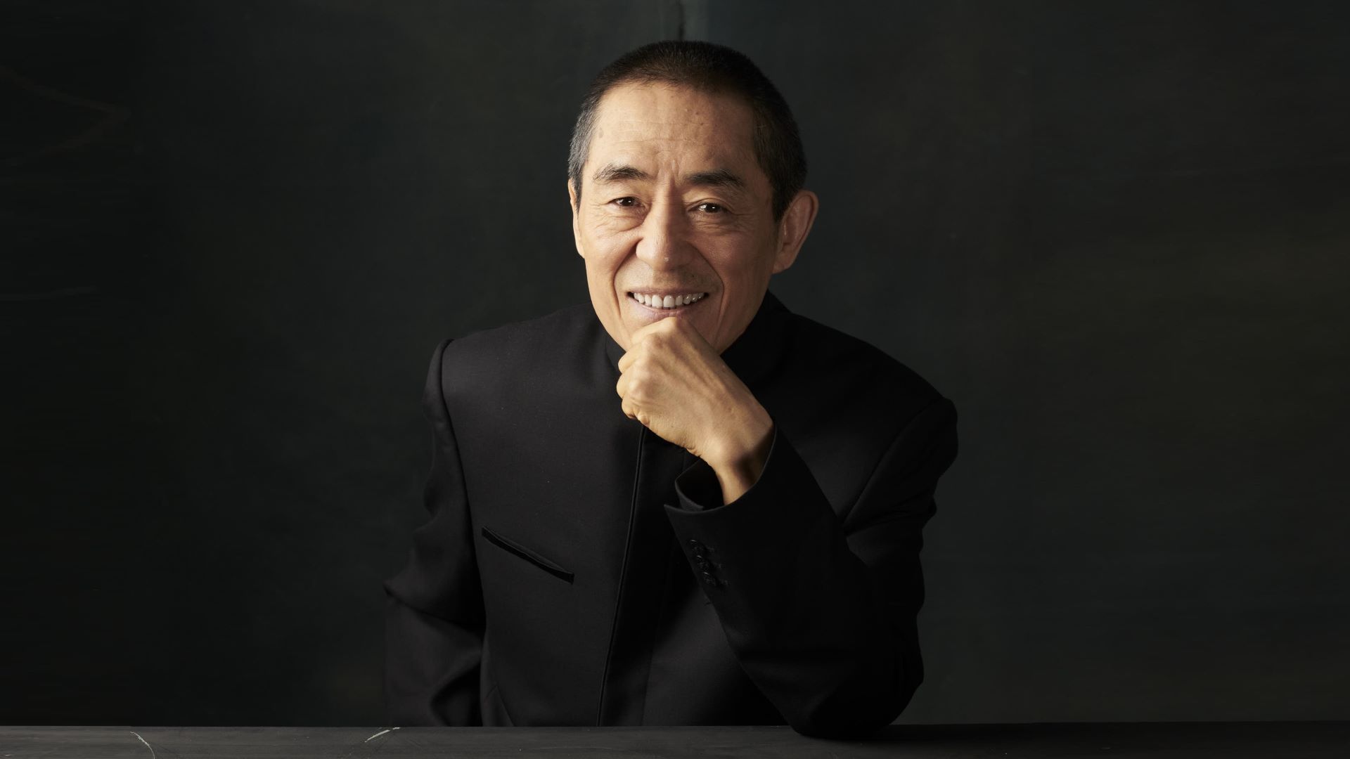 Smiling Zhang Yimou wearing a black suit