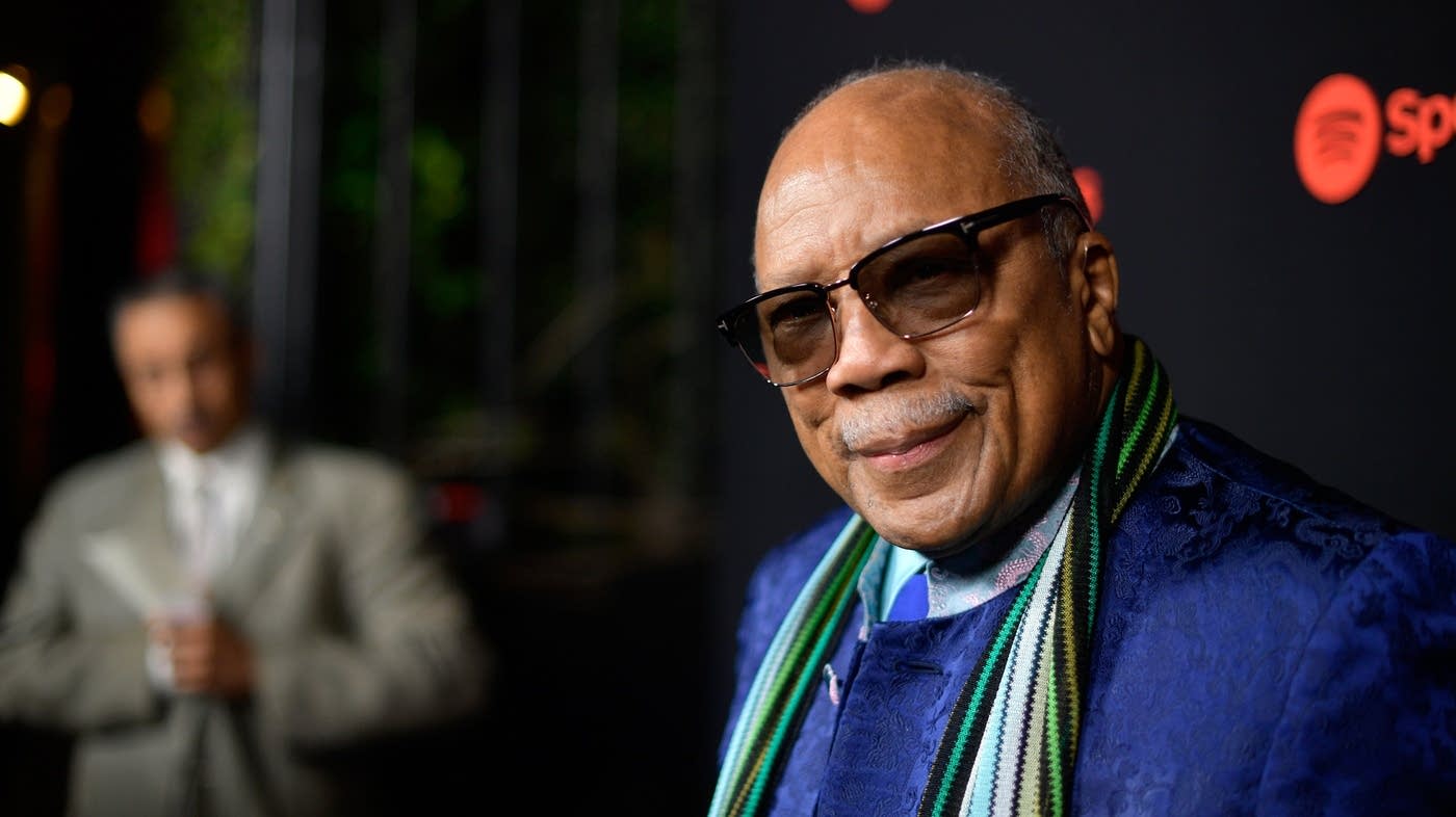 Quincy Jones wearing a blue coat and colorful scarf