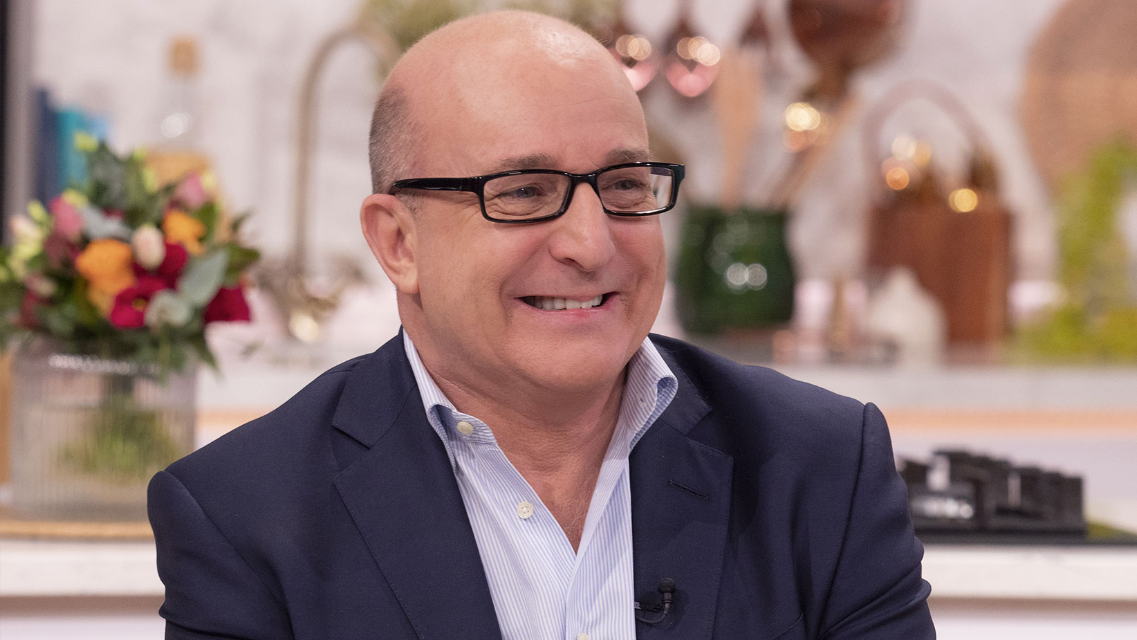 Smiling Paul McKenna wearing a blue suit 