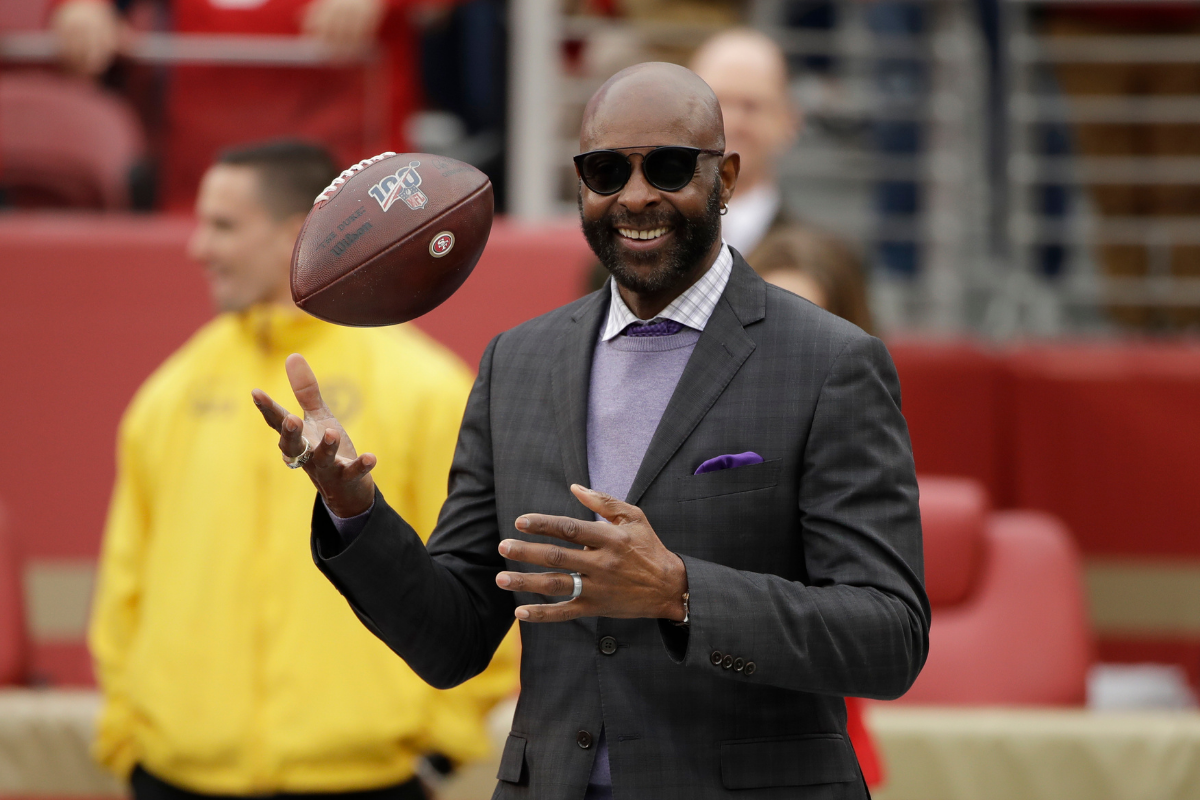 Jerry Rice wwearing a black suit and sunglasses