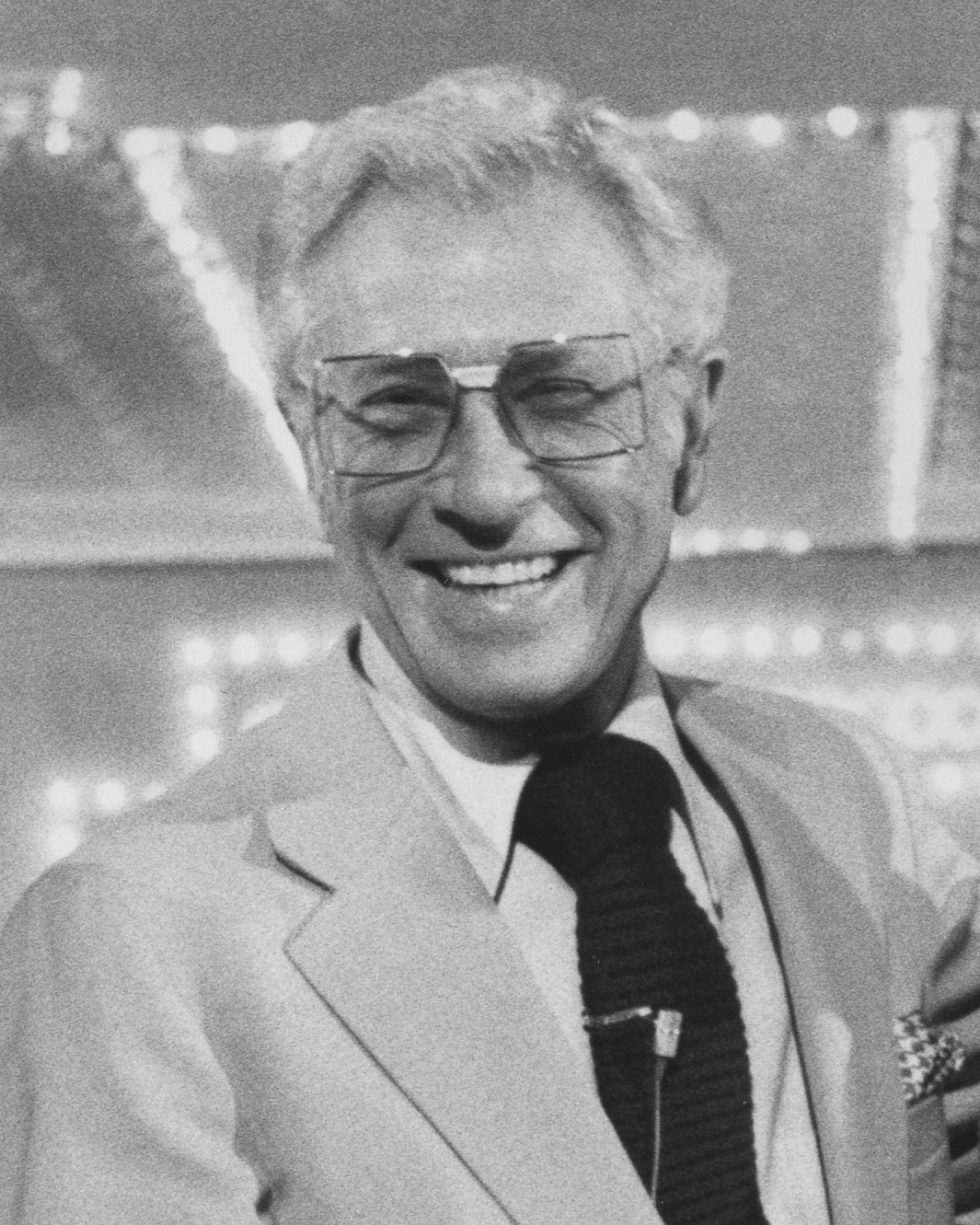 Smiling Allen Ludden wearing a suit and eyeglasses