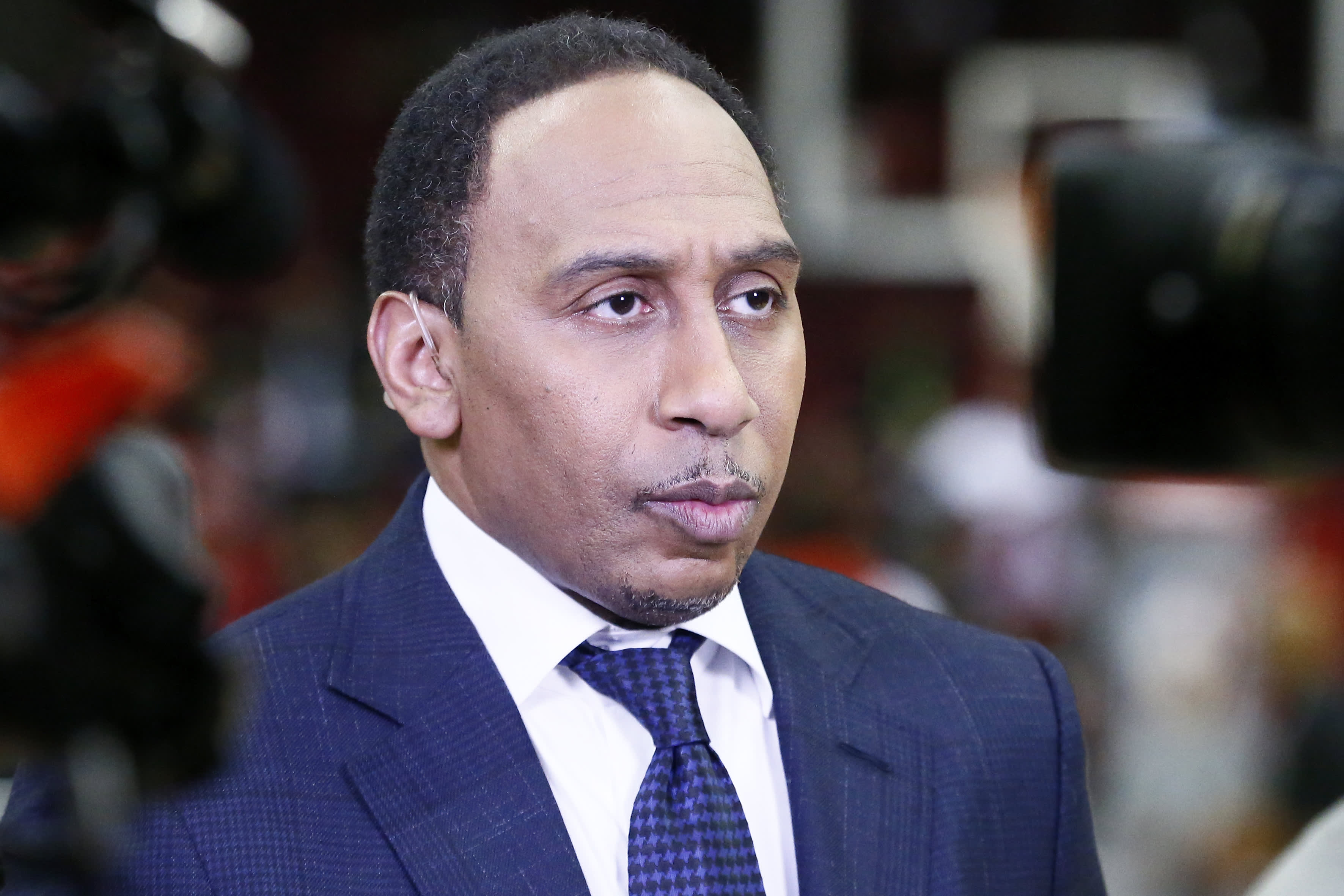 Stephen A Smith wearing a suit and checkered tie