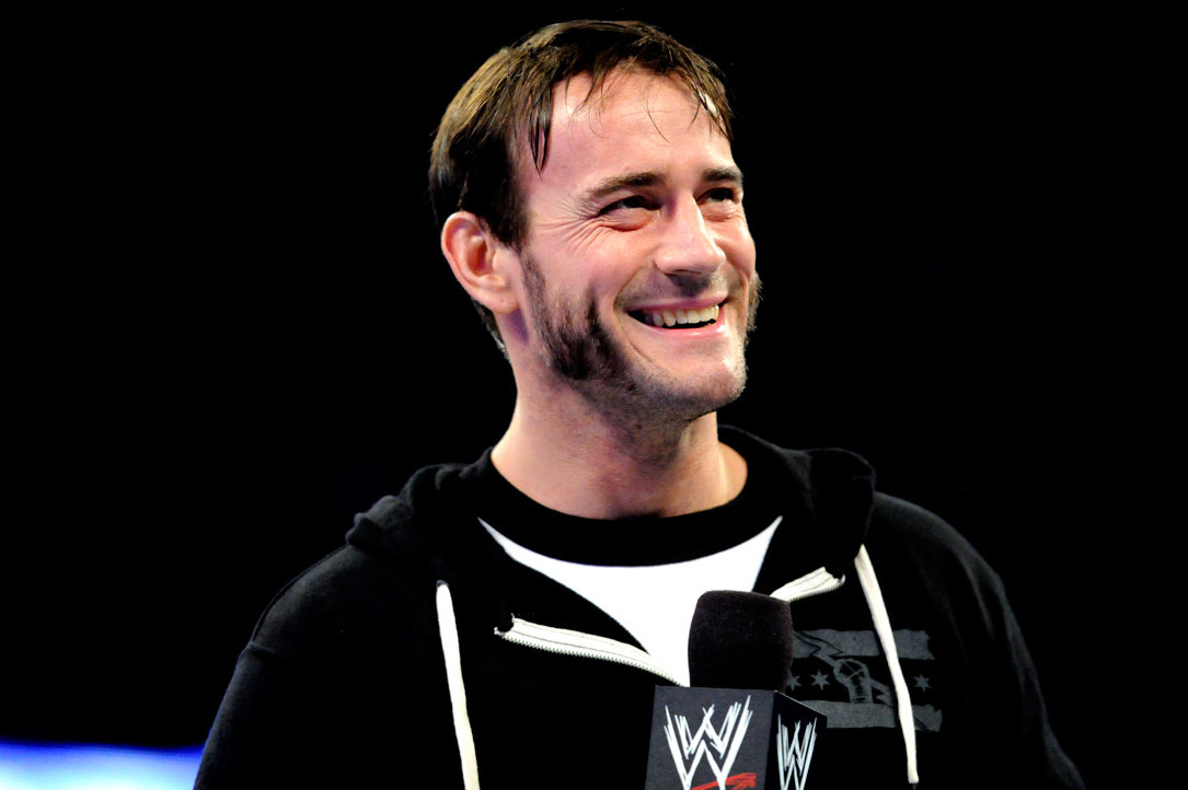 CM Punk wearing a black jacket while holding a mic