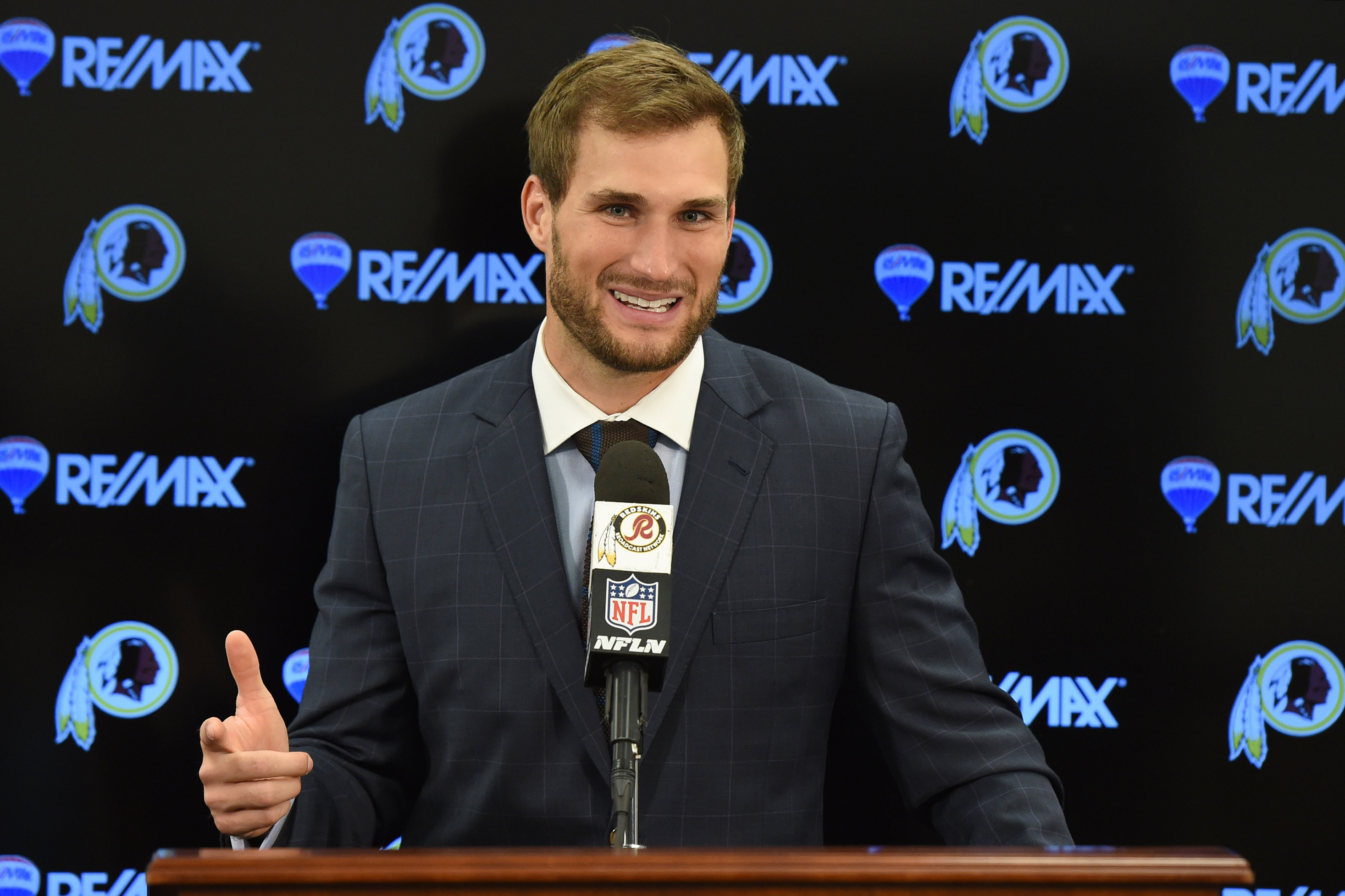 Kirk Cousins wearing a black suit while talking on a mic