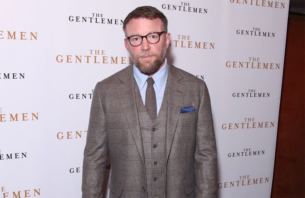 Guy Ritchie wearing a plaid gray suit