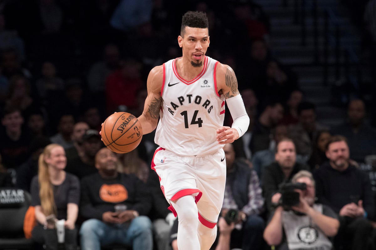 Danny Green wearing white basktball jersey while dribbling a ball