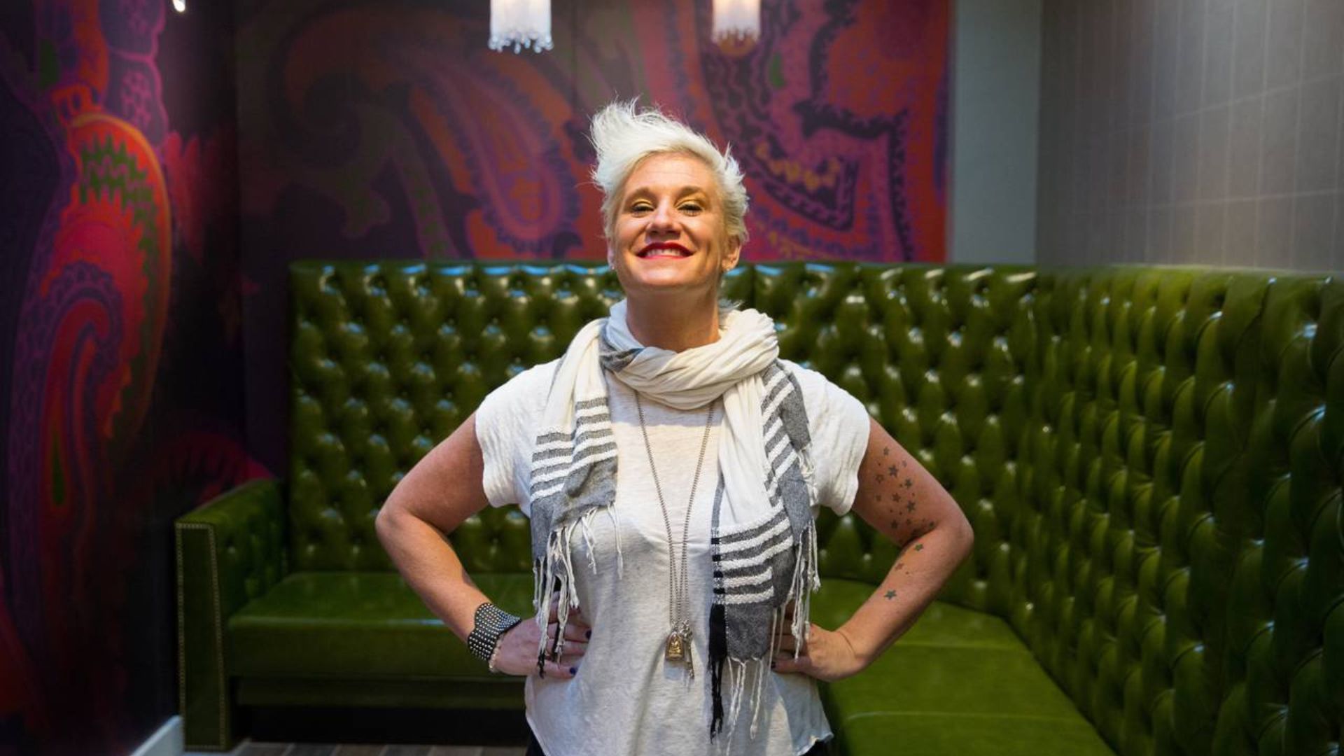 Anne Burrell Smiling And Standing Near A Green Sofa