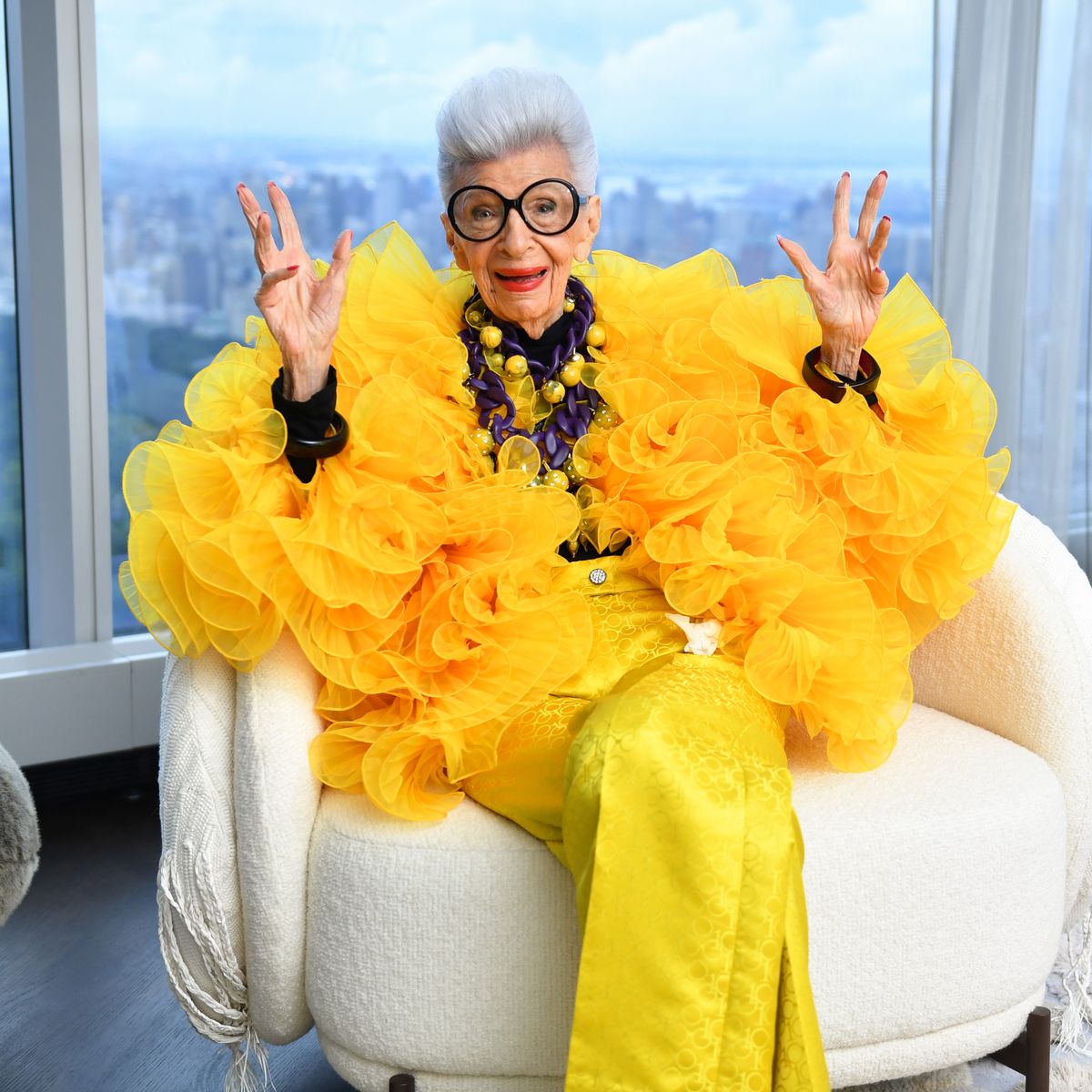 Iris Apfel wearing yellow clothes at a conference