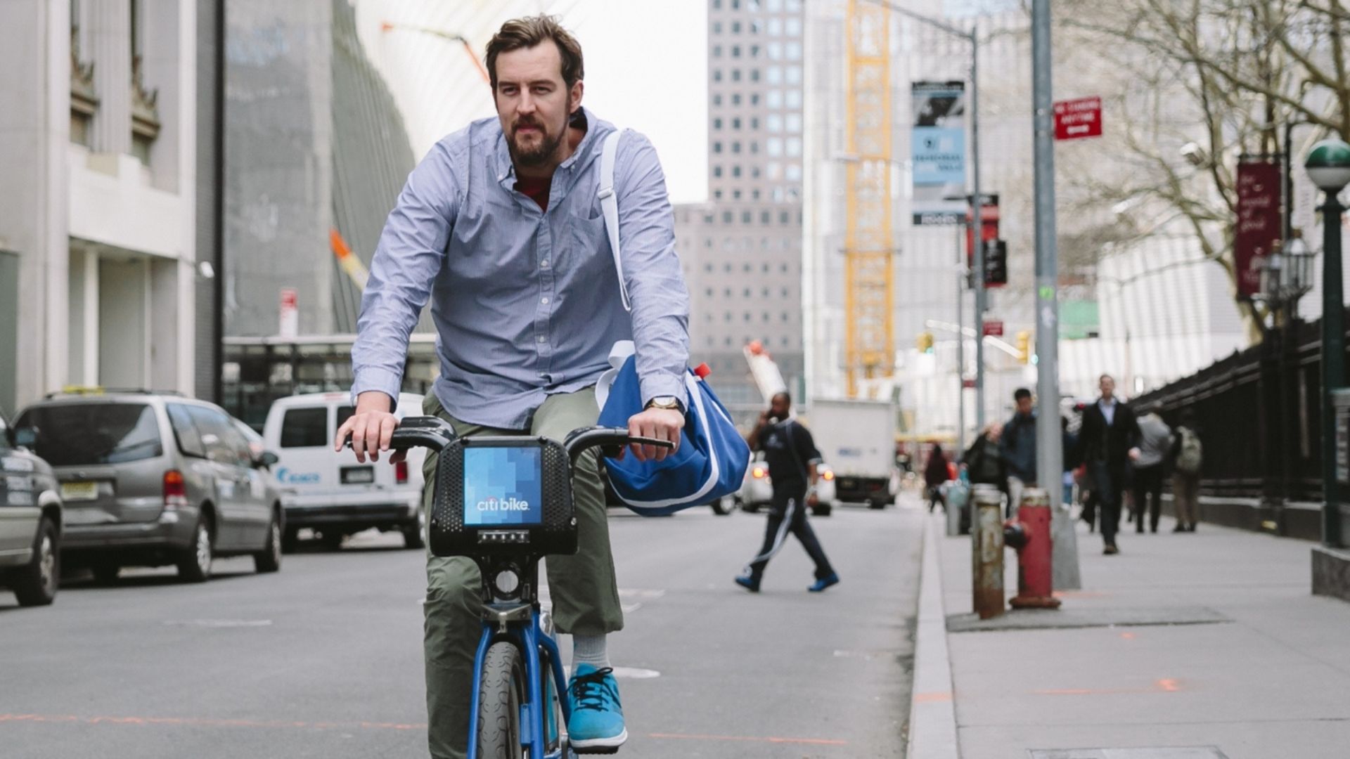 Miguel Wework On A Bicycle With A Blue Bag