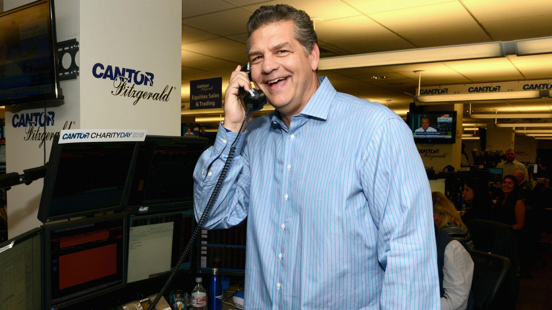 Mike Golic wearing a blue polo long sleeves with a black telephone on his ears