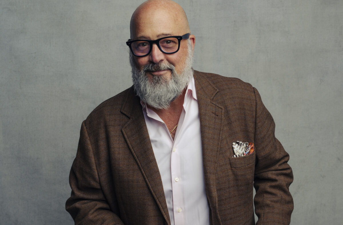 Andrew Zimmern wearing a brown suit