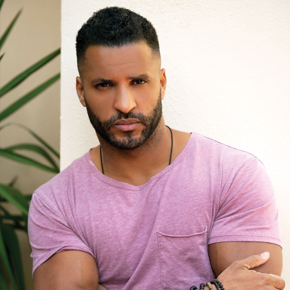 Ricky Whittle wearing a pink t-shirt