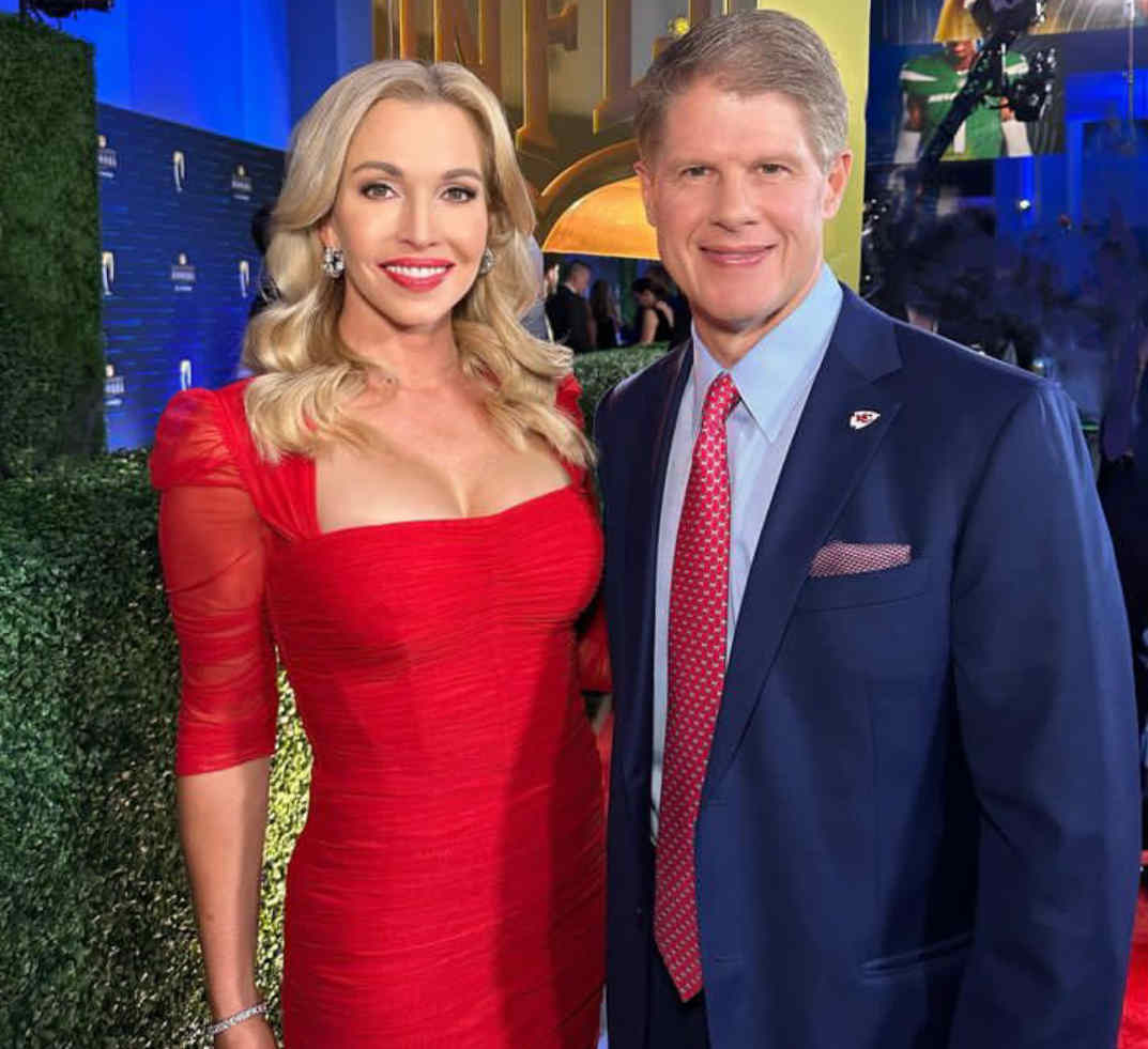 Tavia Shackles Hunt wearing a red dress and Clark Hunt wearing a blue suit