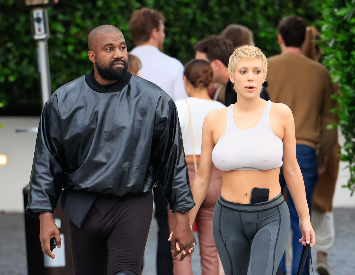 Kanye West wearing a black jacket and Bianca Censori wearing a white sports bra