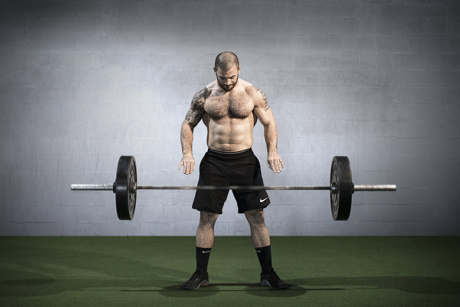 Mat Fraser wearing a black shorts with barbell